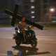 Illustration for article titled Oh Hey, Its a Naked Man on a Scooter, Carrying a Crucifix